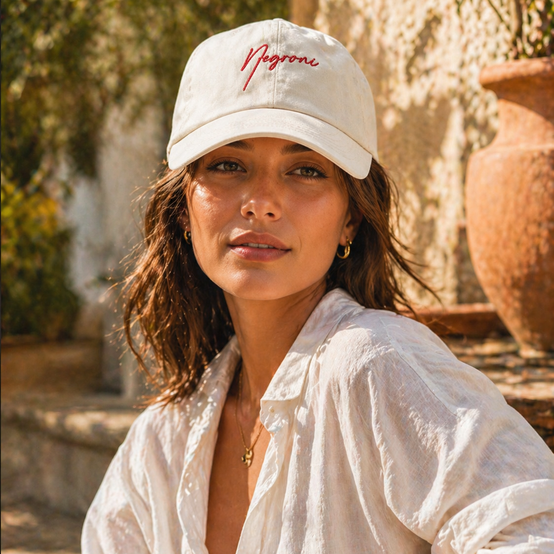 Woman wearing a white cap with 'Nugron' logo outdoors